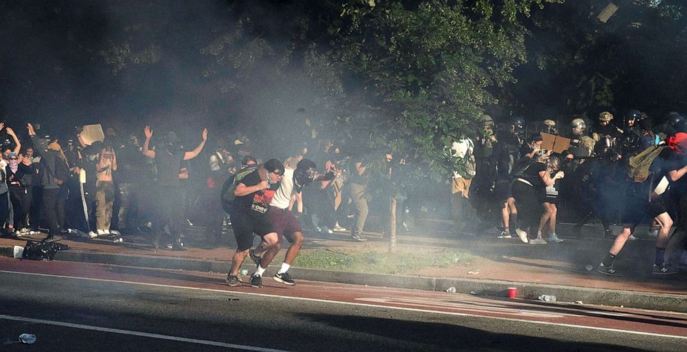 PHOTO: Protestors run as riot police fire tear gas to clear Lafayette Park and the area across from the White House for President Donald Trump to be able to walk to St. John's Episcopal Church for a photo opportunity, in Washington, D.C., June 1, 2020.