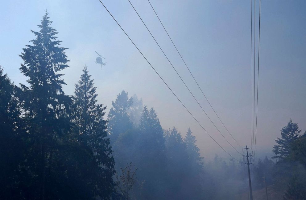 PHOTO: A water-drop helicopter flies near a wildfire burning south of Seattle in Bonney Lake, Wash., Sept. 9, 2020.