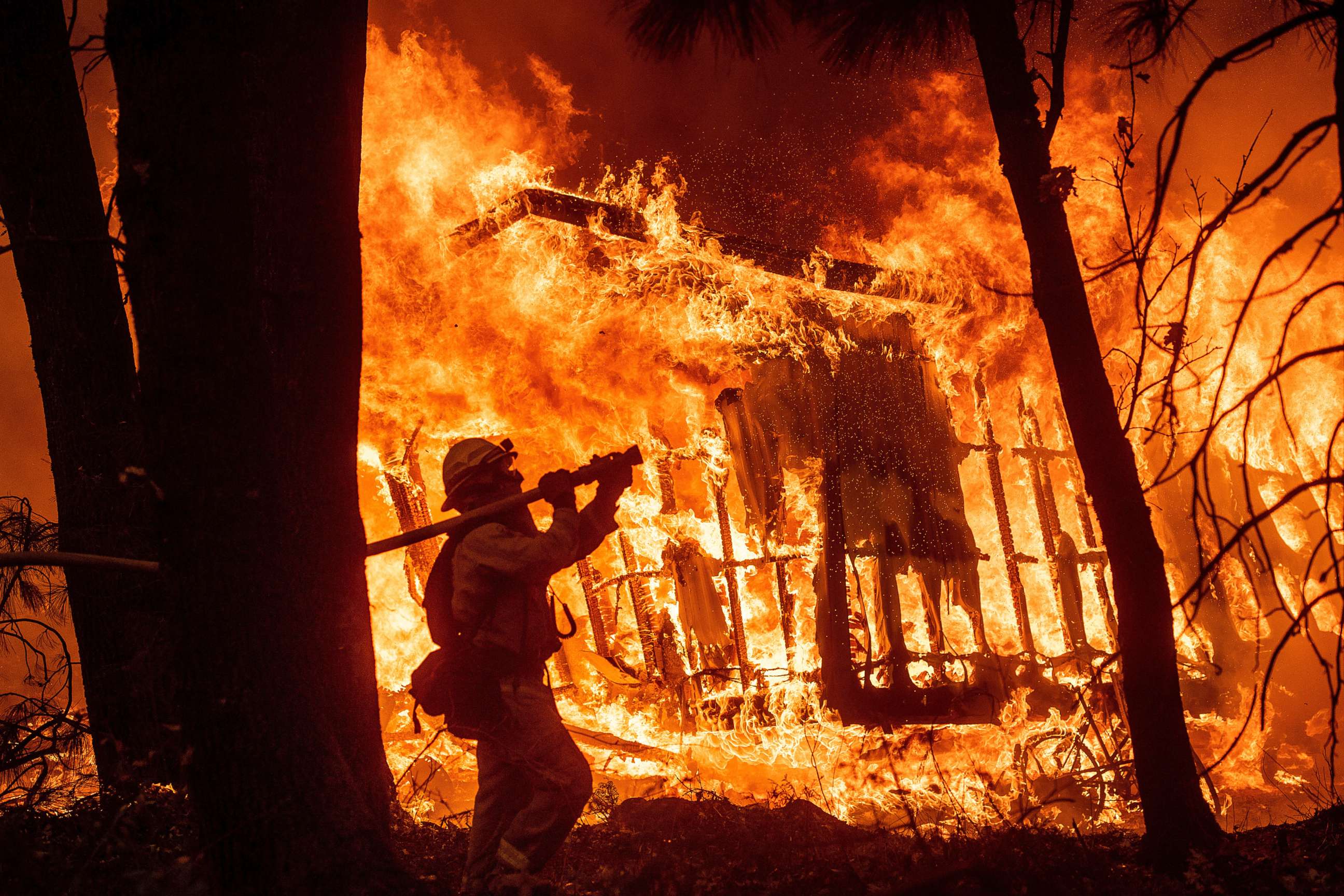 PHOTO: Firefighter Jose Corona sprays water as flames from the Camp Fire consume a home in Magalia, Calif., Nov. 9, 2018.