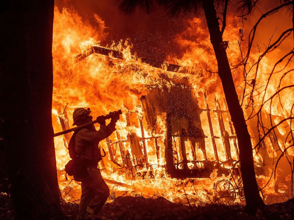 PHOTO: Firefighter Jose Corona sprays water as flames from the Camp Fire consume a home in Magalia, Calif., Nov. 9, 2018.