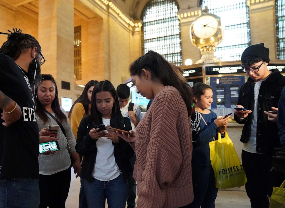 PHOTO: People look at their phones in Grand Central Station in New York City on Oct. 3, 2018, as they receive an emergency test "Presidential alert"  message.