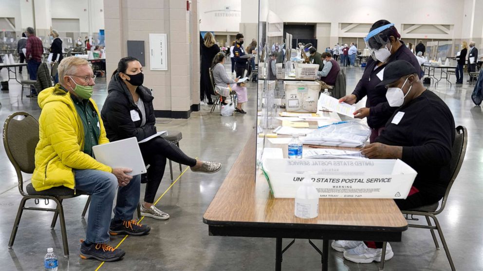 PHOTO: Election workers, right, verify ballots as recount observers, left, watch during a Milwaukee hand recount of presidential votes at the Wisconsin Center, Nov. 20, 2020, in Milwaukee.