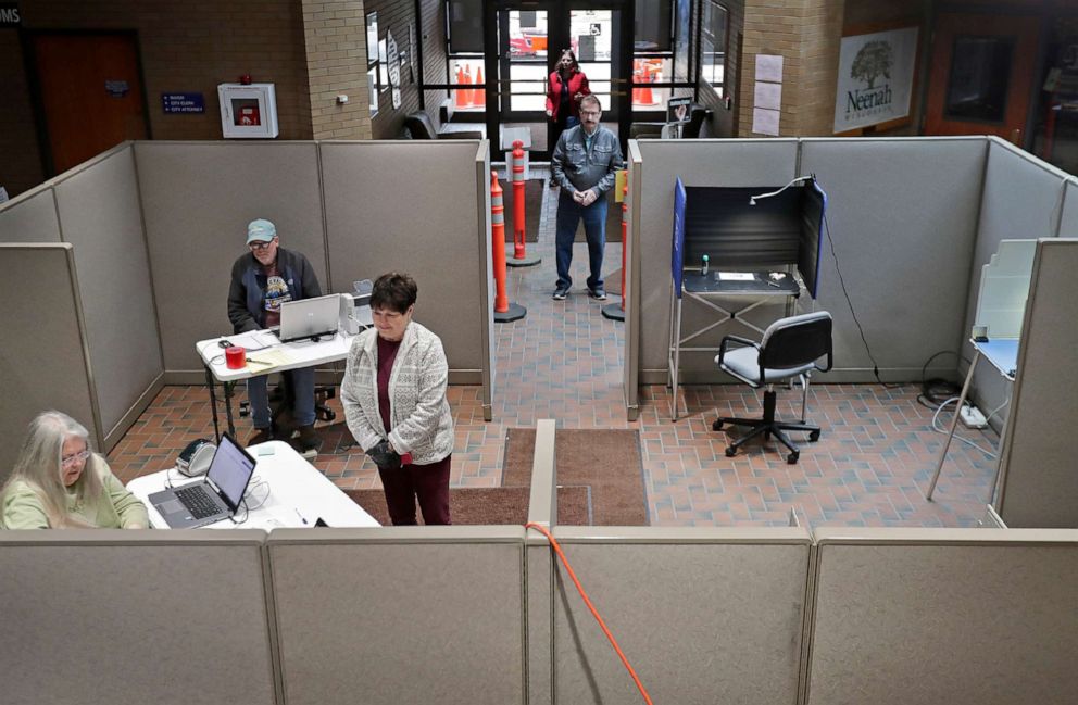 PHOTO: Early voters maintain a distance from each other while casting their ballots at city hall on March 19, 2020, in Neenah, Wis.