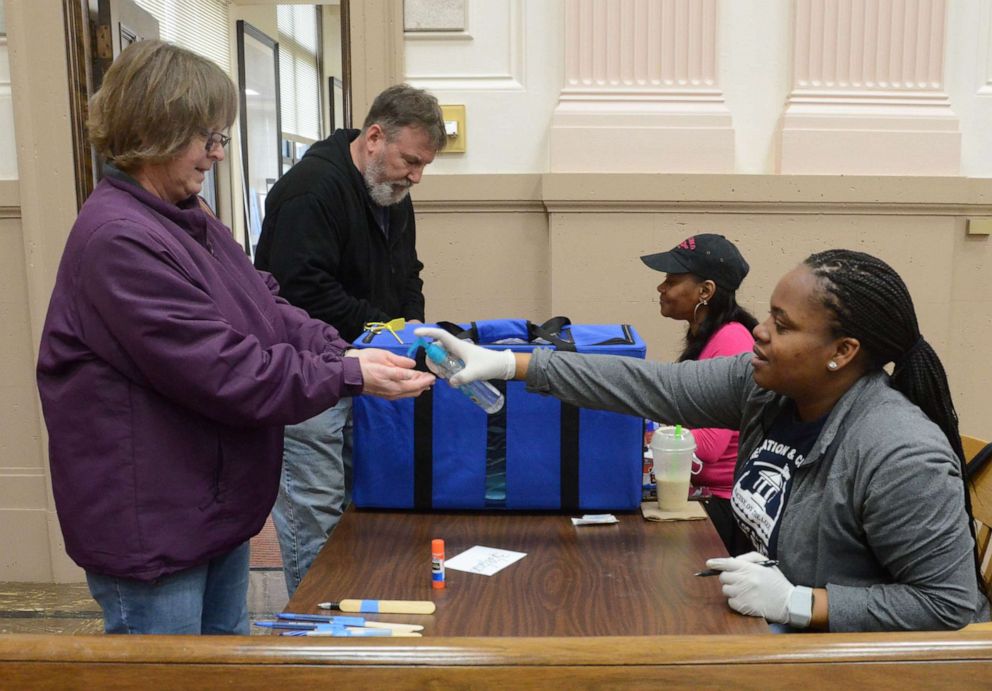 PHOTO: A voter is given hand sanitizer after voting at City Hall in Racine, Wis., March 28, 2020.