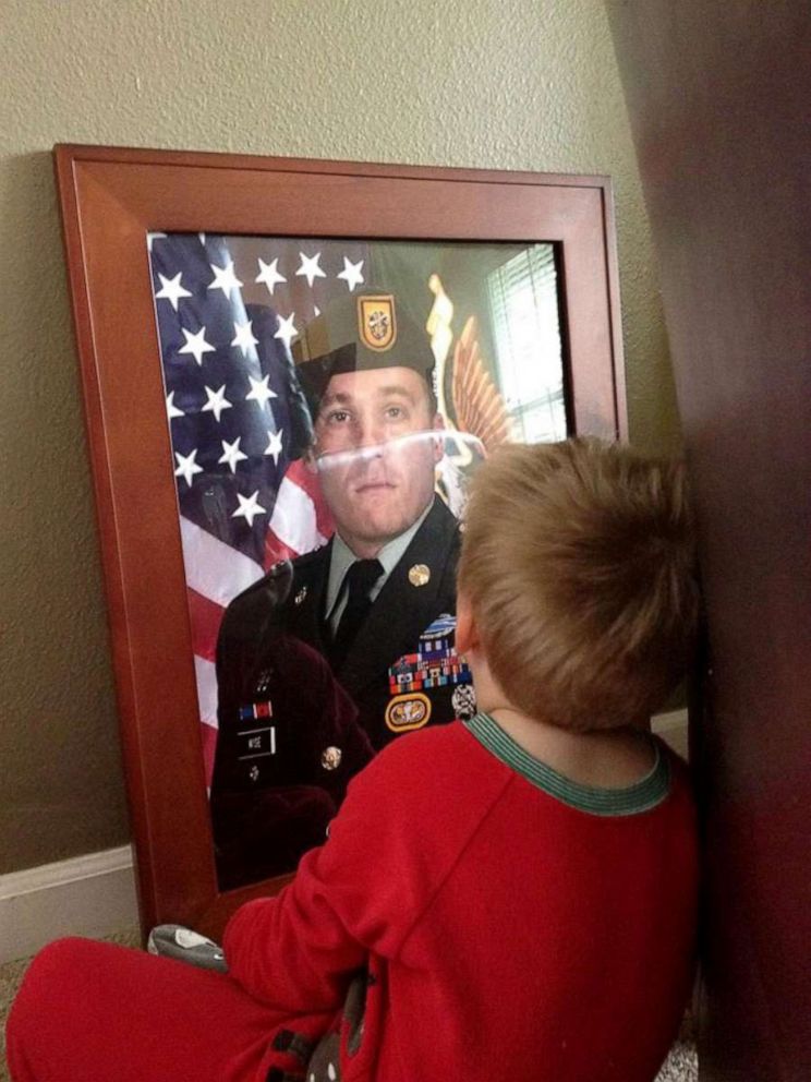 PHOTO: Luke Wise looks at a portrait of his dad, Ben, after his passing.