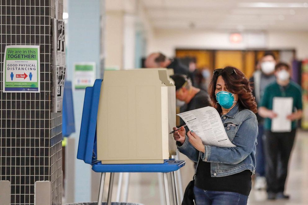 PHOTO: A woman casts her ballot in a Democratic presidential primary election at the Hamilton High School in Milwaukee, April 7, 2020.