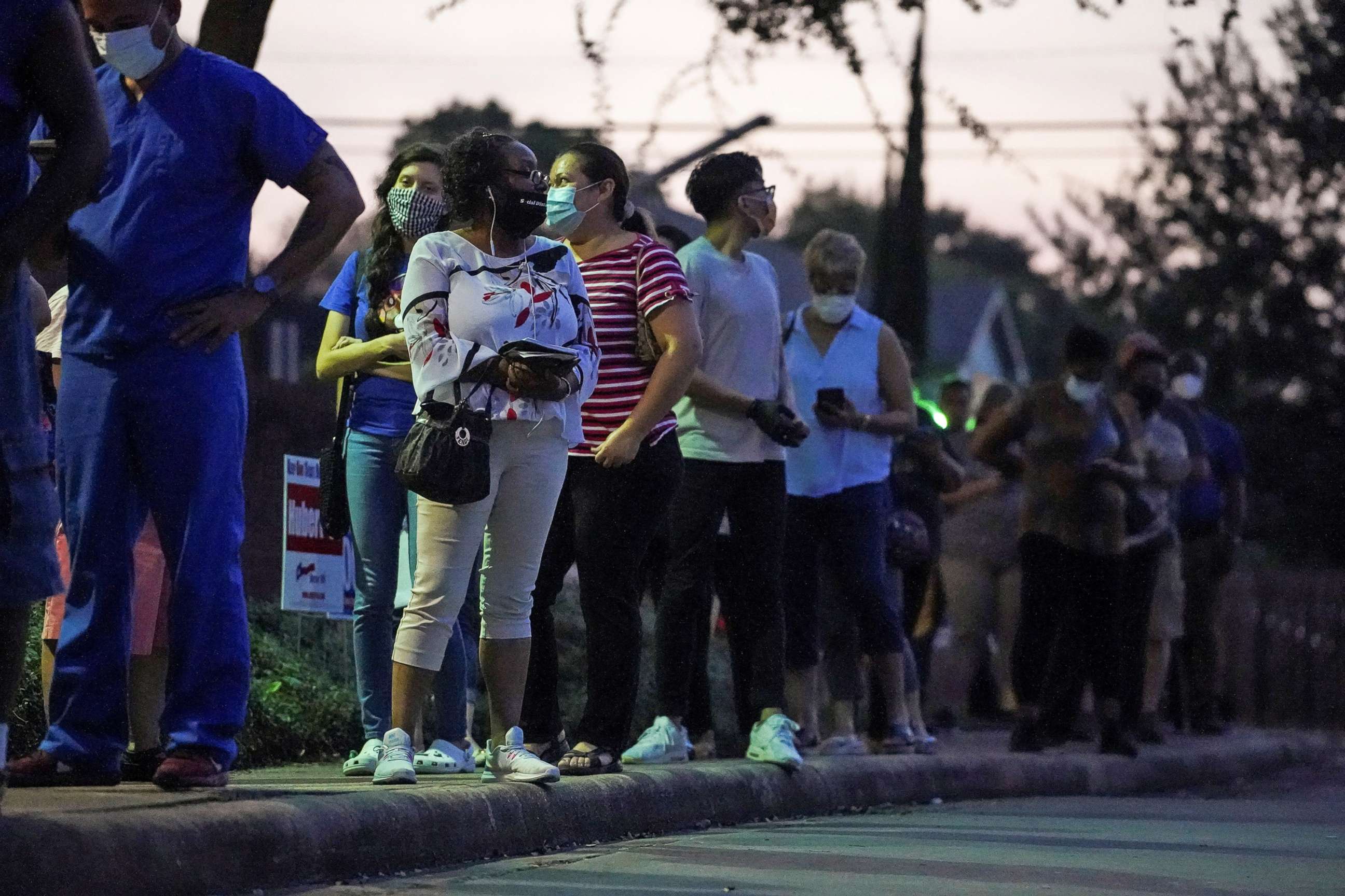PHOTO: People wait in line to cast their ballots for the presidential election as early voting begins in Houston, Oct. 13, 2020.
