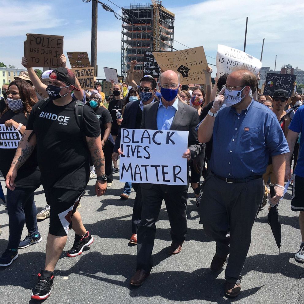 PHOTO: Gov. Tom Wolf, holds a "black lives matter" sign walking alongside Harrisburg Mayor Eric Papenfuse, right, with demonstrators, June 3, 2020 in Harrisburg, Pa.