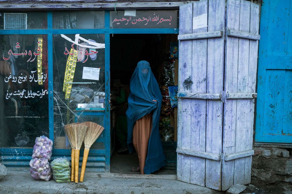 PHOTO: An Afghan woman wearing a burqa exits a small shop in Kabul, Afghanistan, Dec. 5, 2021. 