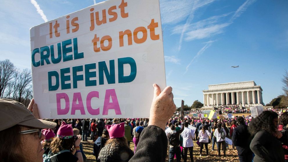 A demonstrator holds a sign saying "It is just cruel to not defend DACA" as thousands of activists gathered on the National Mall and marched to the White House for the 2018 Women's March on Washington D.C., Jan. 20, 2018.