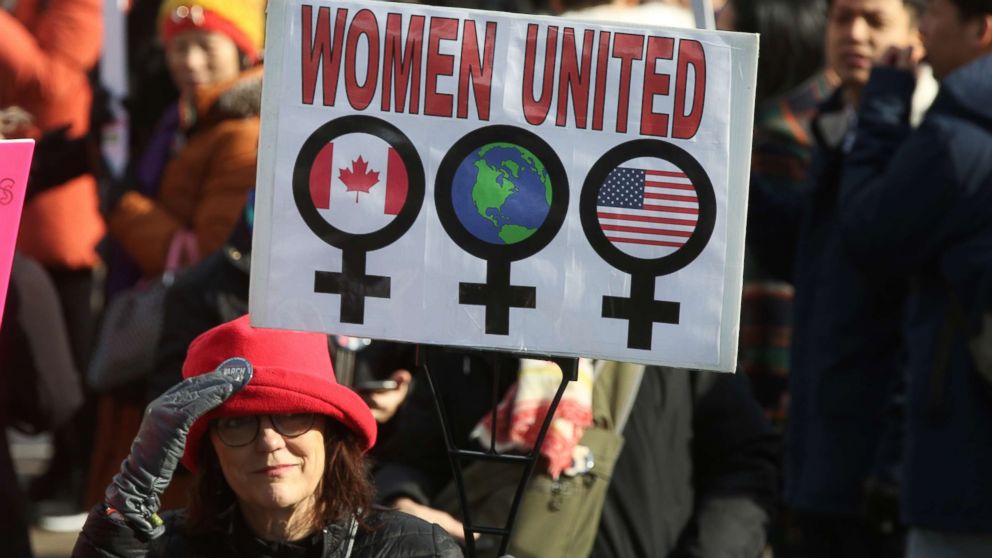 PHOTO: Woman holding a sign saying "Women United" as hundreds take part in the Women's March in downtown Toronto, Canada, Jan. 20, 2018.
