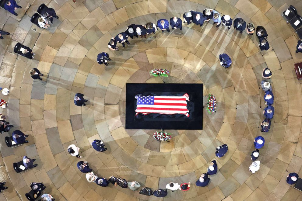 PHOTO:  Family members stand in a circle around Herschel  "Woody " Williams' flag-draped casket laying in honor in the US Capitol Rotunda on July 14, 2022 in Washington, DC. 