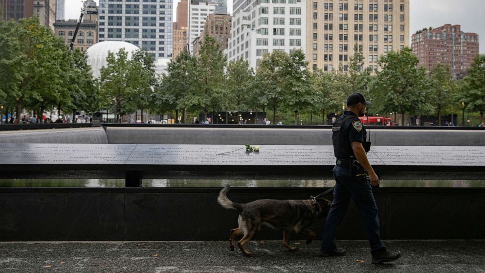 PHOTO: A law enforcement officer walks with a k-9 dog near 9/11 Memorial before memorial observances held at the site of the World Trade Center in New York, Sept. 9, 2021.