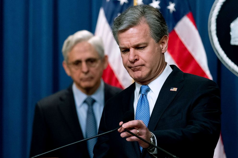 PHOTO: FBI Director Christopher Wray, accompanied by Attorney General Merrick Garland, left, takes the podium to speak at a news conference at the Justice Department in Washington, D.C., April 6, 2022.