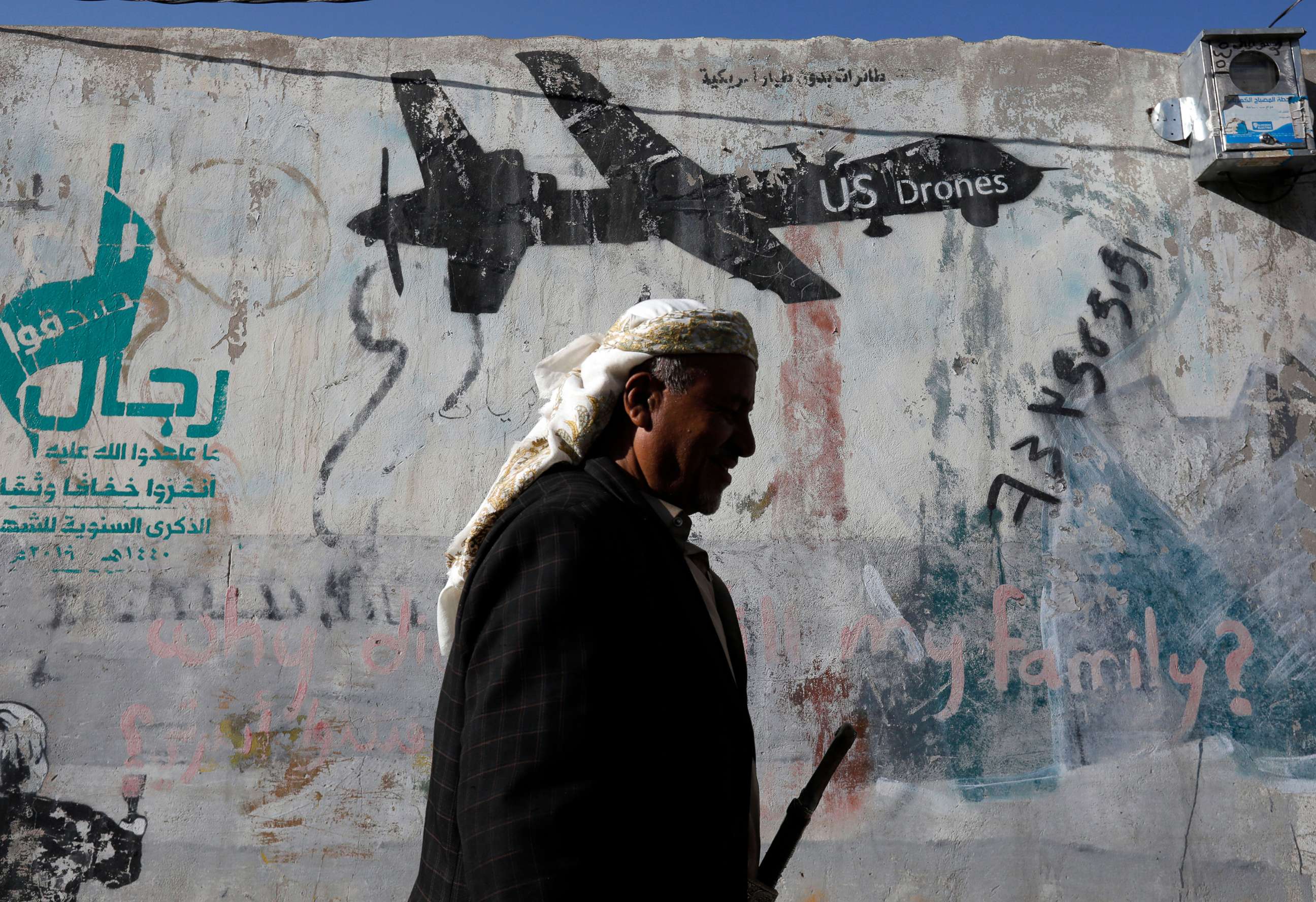PHOTO: A Yemeni walks past graffiti depicting a U.S. drone, after a raid killed an al-Qaeda leader, Qassim al-Rimi, in Yemen, in Sana'a, Yemen, Feb. 1, 2020.