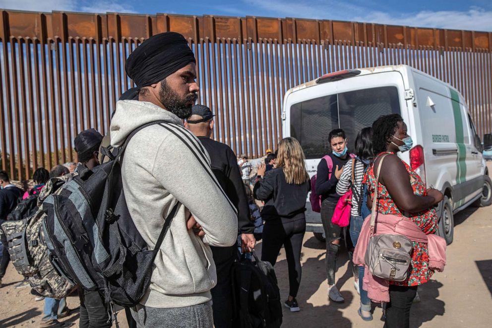 PHOTO: In this Dec. 9, 2021, file photo, immigrants from India and Haiti wait with others to be transported to a U.S. Border Patrol processing center in Yuma, Ariz.