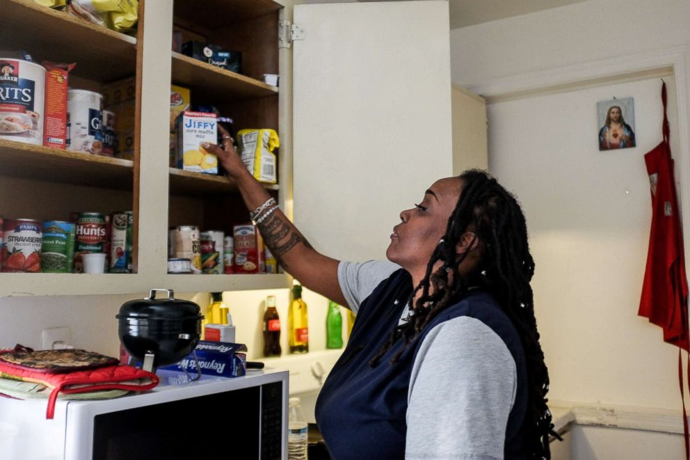 PHOTO: Yvette Hicks looks at free food that she has received from local food banks to feed her children during the shutdown at her apartment in Washington, Jan. 25, 2019.