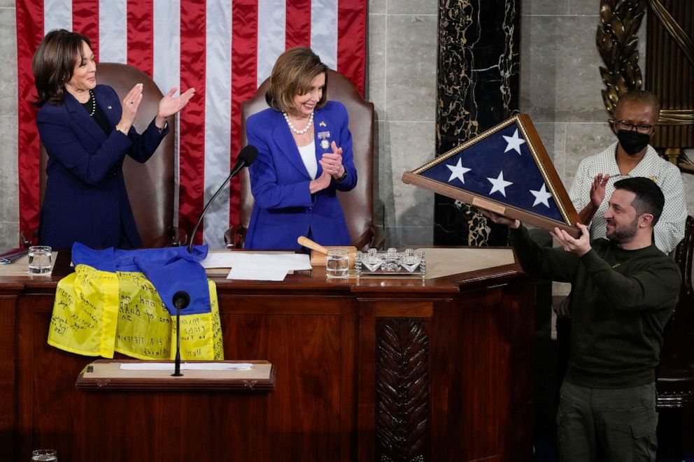 PHOTO : Le président ukrainien Volodymyr Zelenskyy, à droite, brandit un drapeau américain qui lui a été offert par la présidente de la Chambre Nancy Pelosi de Californie et la vice-présidente Kamala Harris, à Washington, le 21 décembre 2022.
