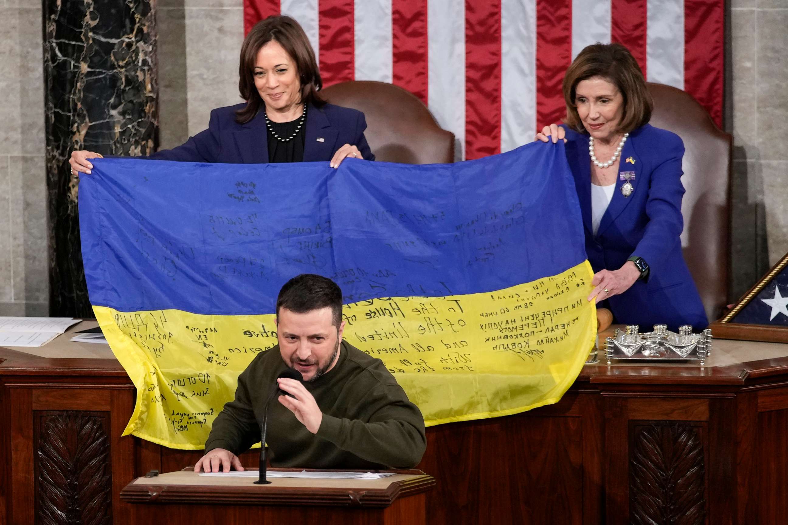 PHOTO: Vice President Kamala Harris and House Speaker Nancy Pelosi of Calif. hold a Ukrainian flag autographed by front-line troops that Ukrainian President Volodymyr Zelenskyy presented to lawmakers on Capitol Hill in Washington, on Dec. 21, 2022.