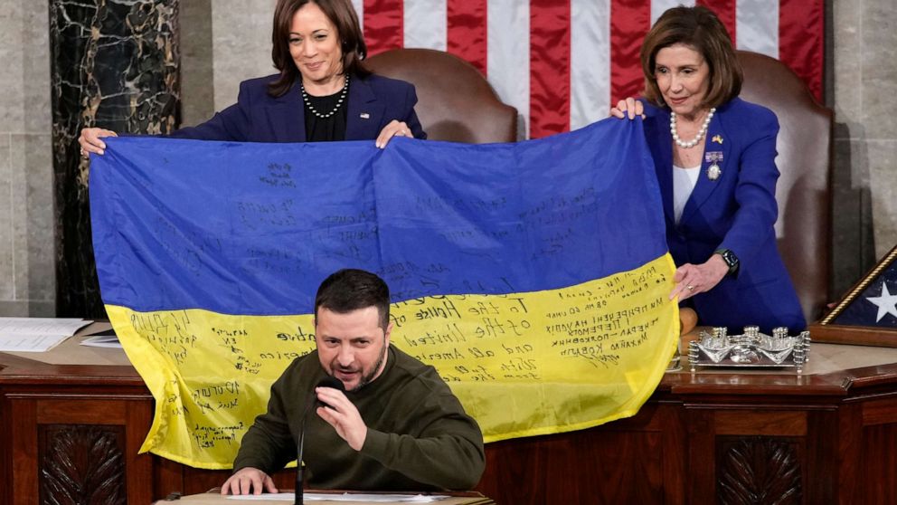 PHOTO : Le vice-président Kamala Harris et la présidente de la Chambre Nancy Pelosi de Californie tiennent un drapeau ukrainien dédicacé par les troupes de première ligne que le président ukrainien Volodymyr Zelenskyy a présenté aux législateurs sur la colline du Capitole à Washington, le 21 décembre 2022.