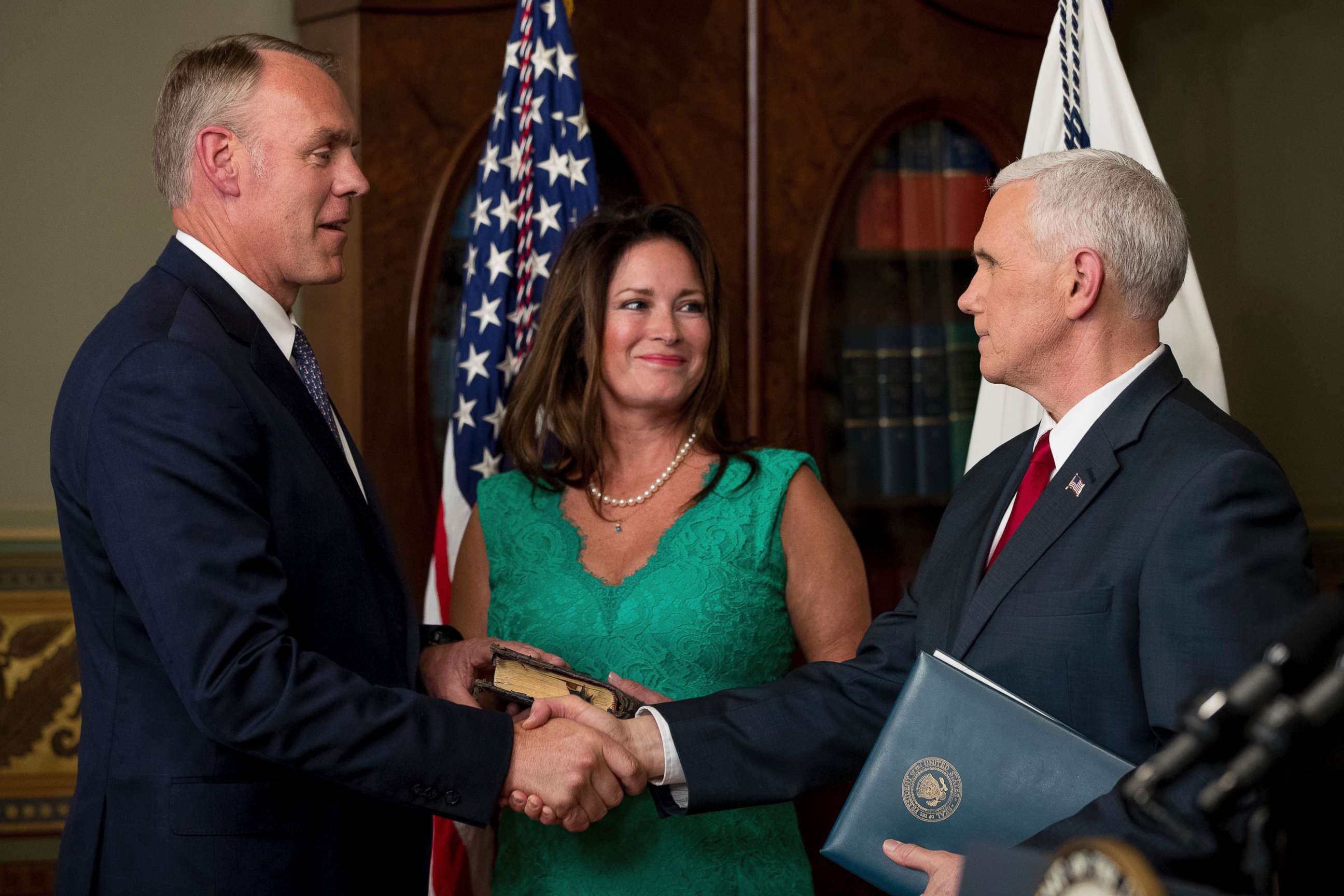 PHOTO: Vice President Mike Pence, right, shakes hands after administering the oath of office to Interior Secretary Ryan Zinke, left, with his wife Lolita Hand, center, March 1, 2017, in the Eisenhower Executive Office Building on the White House complex. 