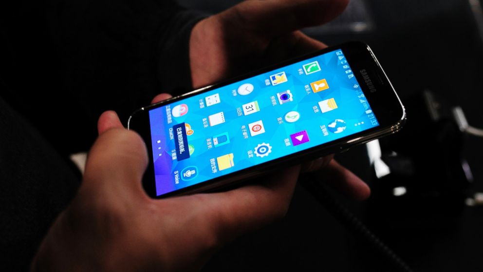 The new Samsung Galaxy S5 is examined by a visitor to the Mobile World Congress in Barcelona, Spain, Feb. 24, 2014. 