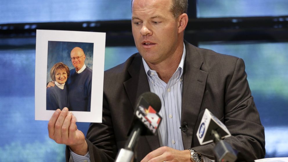 Attorney Paxton Guymon holds a photograph of Jim and Jan Harding during a news conference in Salt Lake City, Aug. 14, 2014.