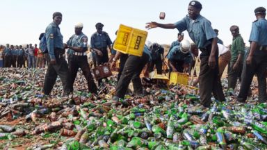 PHOTO: Sharia enforcers called Hisbah destroy thousands of bottles of beer outside northern Nigerias largest city of Kano on November 27, 2013.