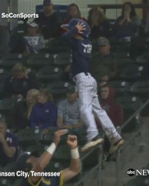 Aaron Maher, a player on East Tennessee State University's baseball team, shares an epic handshake with the team's bat boy after scoring.