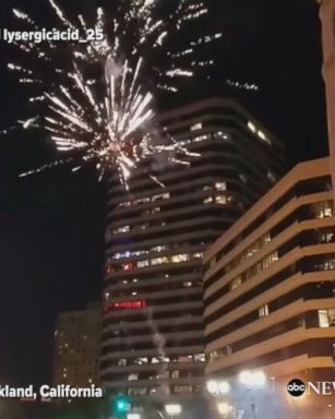 Fireworks light up the skies in Oakland as Golden State Warriors fans dance in the street to celebrate their team's victory in the NBA Finals.