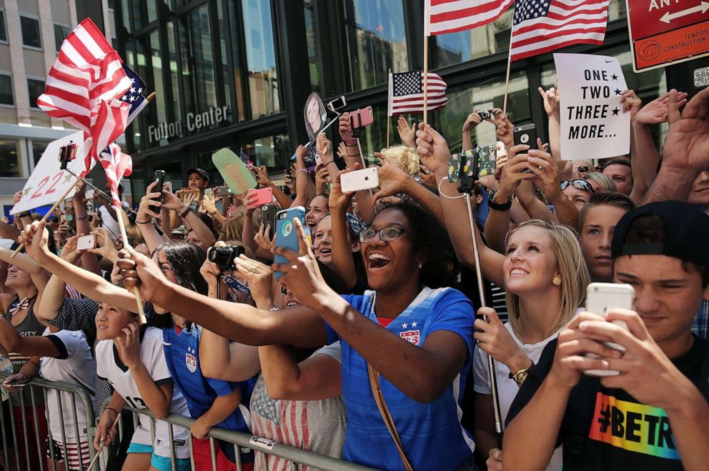PHOTO: Fans cheer as the World Cup-winning U.S. women's soccer team make their way up the The Canyon of Heroes during a  ticker-tape parade on July 10, 2015 in New York City.