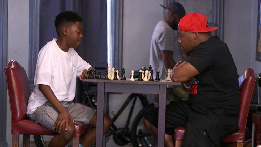 PHOTO: Cahree Myrick, 12, plays his local barber in chess after winning his first national title earlier this year. 