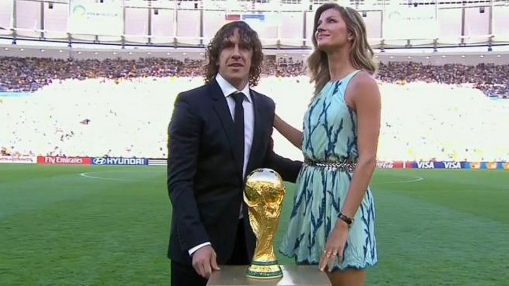 Former Spanish team captain Carles Puyol of Spain and model Gisele Bundchen pose with the World Cup trophy prior to the World Cup final soccer match between Germany and Argentina at the Maracana Stadium in Rio de Janeiro, July 13, 2014.