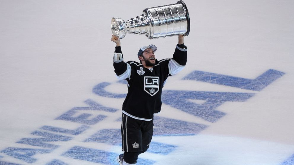 Los Angeles Kings defenseman Alec Martinez carries the Stanley Cup after beating the New York Rangers in Game 5 of the NHL Stanley Cup Final series Friday, June 13, 2014, in Los Angeles. The Kings won, 3-2, with Martinez scoring the winning goal in double overtime.