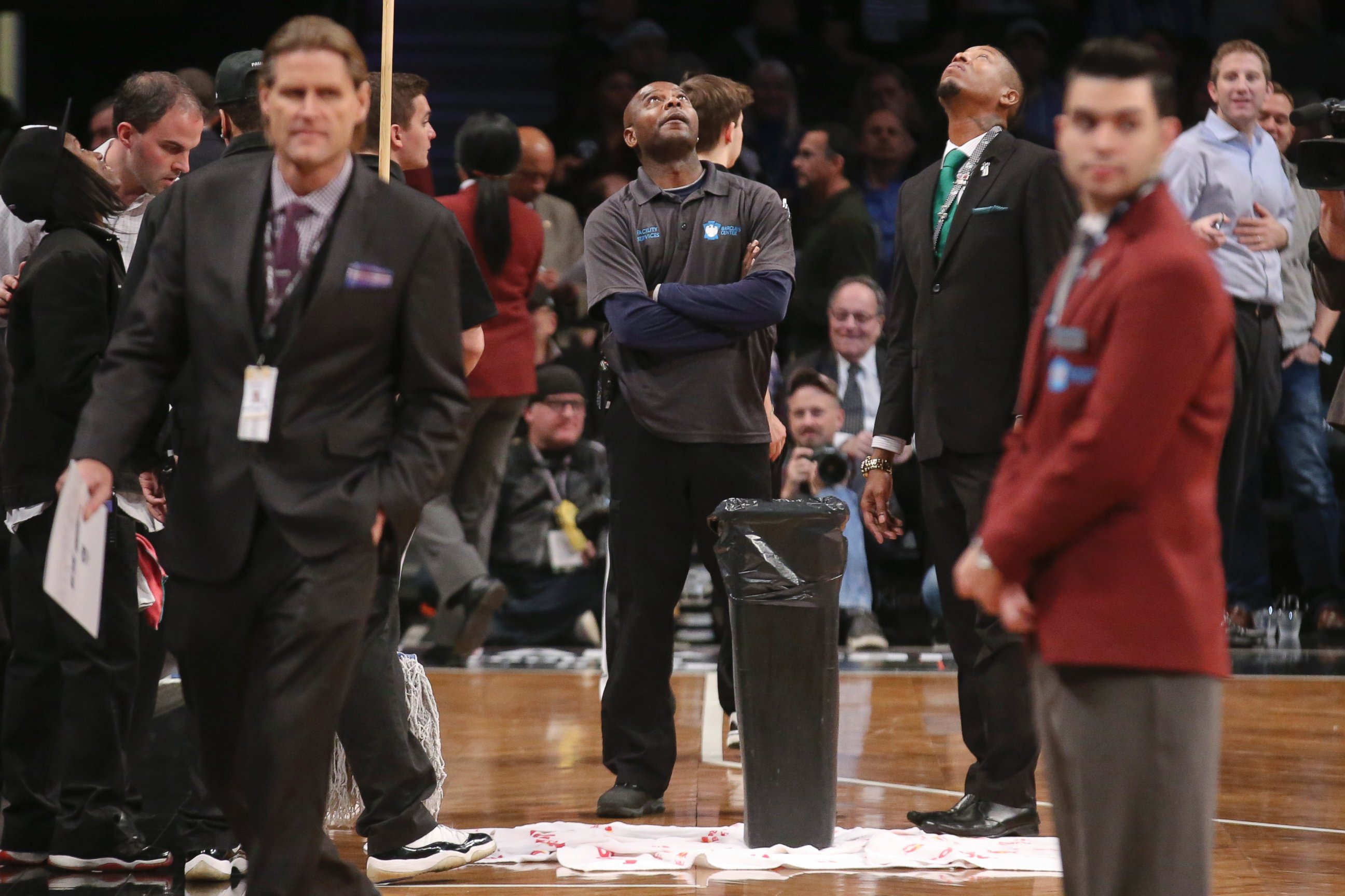 PHOTO: Floor attendants look up at a roof leak causing a delay in the first half an NBA basketball game between the Brooklyn Nets and Miami Heat at the Barclays Center, Dec. 16, 2014, in New York.