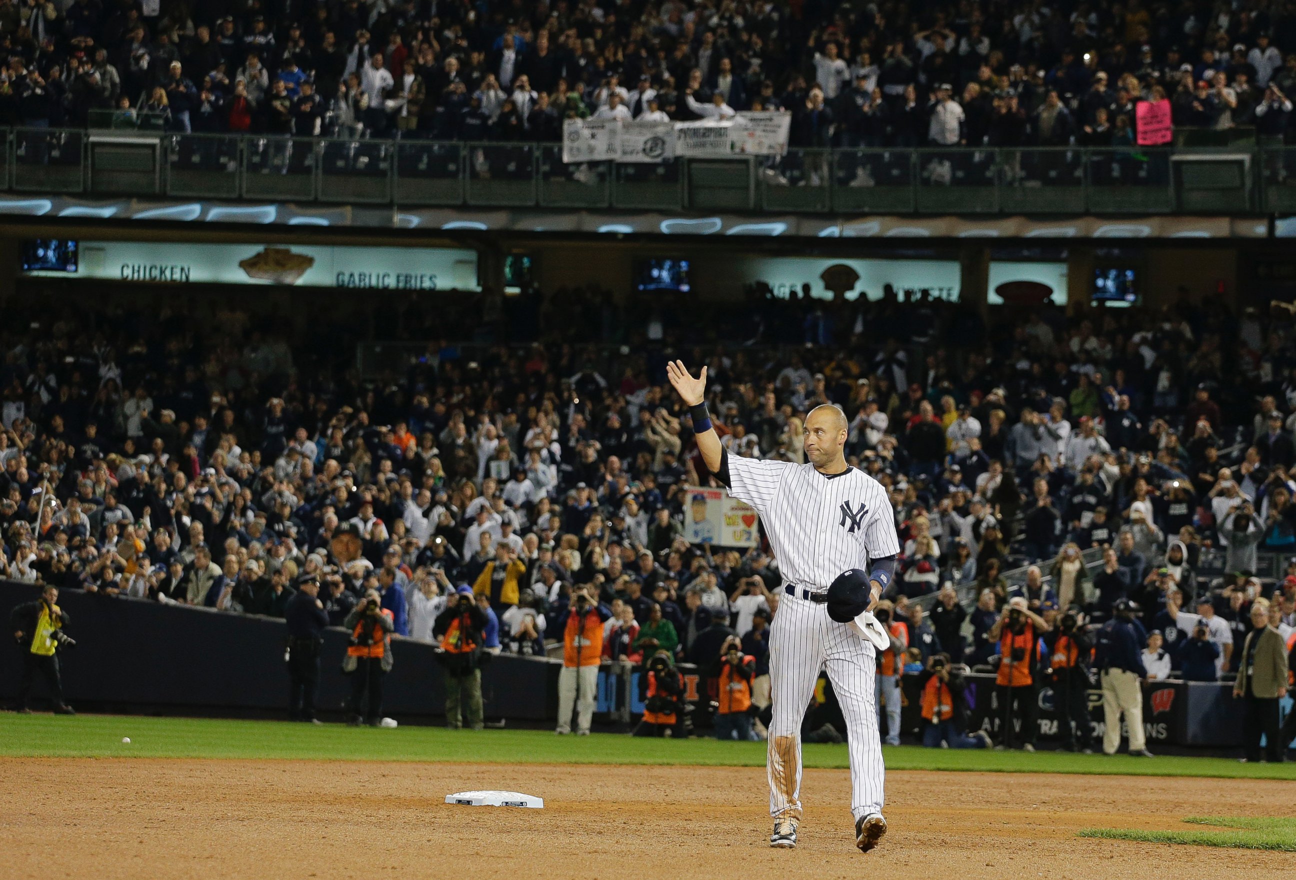New York Yankees shortstop Derek Jeter waves to fans as he walks around the infield after driving in the winning run against the Baltimore Orioles in the ninth inning of a baseball game, Thursday, Sept. 25, 2014, in New York. 