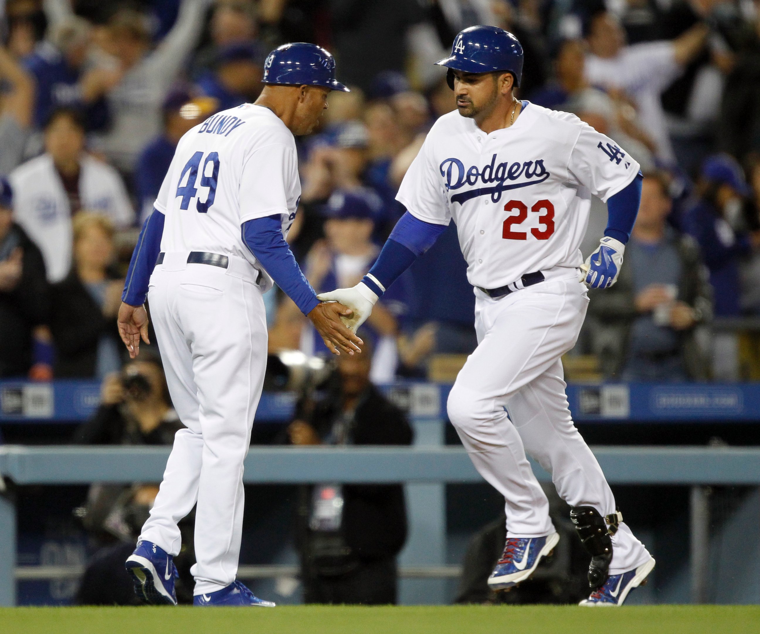 PHOTO: Los Angeles Dodgers third base coach Lorenzo Bundy, left, congratulates Adrian Gonzalez for hitting a solo home run during the third inning, his second of a baseball game against the San Diego Padres in Los Angeles, April 8, 2015.