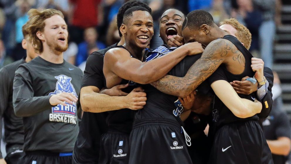 Georgia State players celebrate as they surround R.J. Hunter, center, after he made the game winning shot against Baylor an NCAA tournament second round college basketball game, Thursday, March 19, 2015, in Jacksonville, Fla. Georgia State won 57-56.