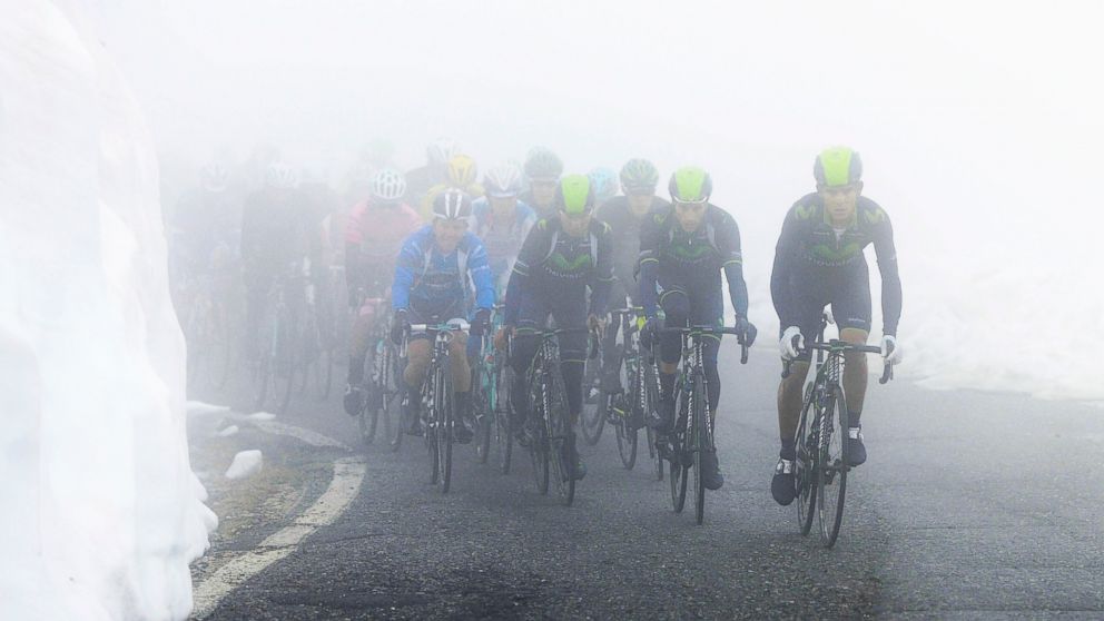 Movistar team cyclists lead the pack as they climb through fog and snow during the 16th stage of the Giro d'Italia cycling race from Ponte di Legno to Val Martello, Italy, May 27, 2014.