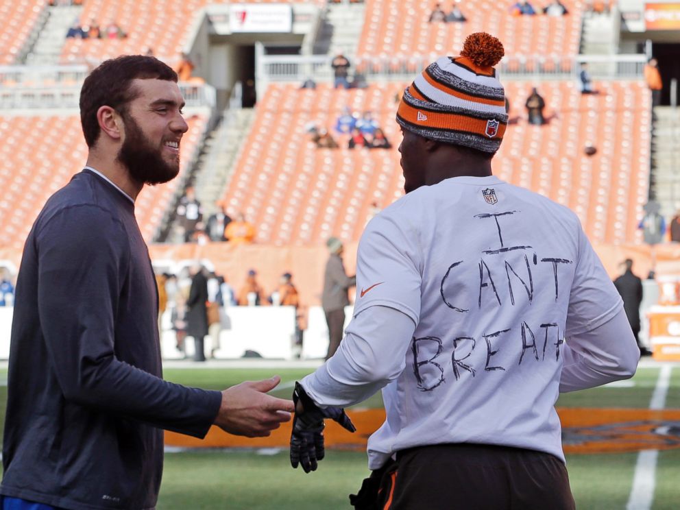 Indianapolis Colts quarterback Andrew Luck, left, talks with Cleveland Browns cornerback Johnson Bademosi before an NFL football game Sunday, Dec. 7, 2014, in Cleveland. 