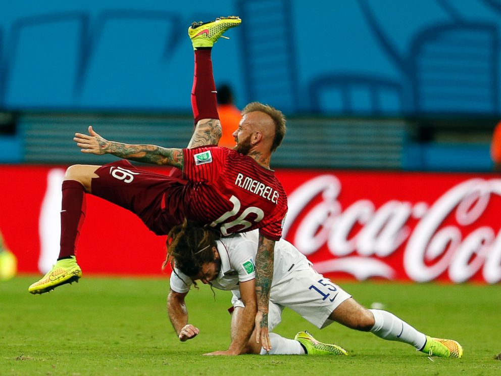 PHOTO: Portugals Raul Meireles falls on top of United States Kyle Beckerman during the group G World Cup soccer match between the United States and Portugal at the Arena da Amazonia in Manaus, Brazil, Sunday, June 22, 2014.