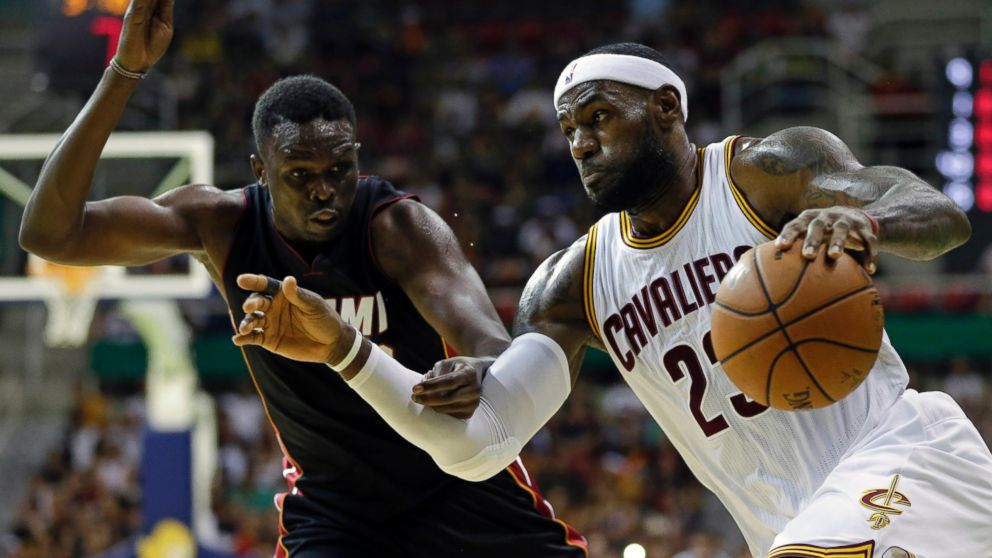 Cleveland Cavaliers' LeBron James, right, drives past Miami Heat's Luol Deng during an NBA preseason basketball game as part of the NBA Global Games, in Rio de Janeiro, Brazil, Oct. 11, 2014.