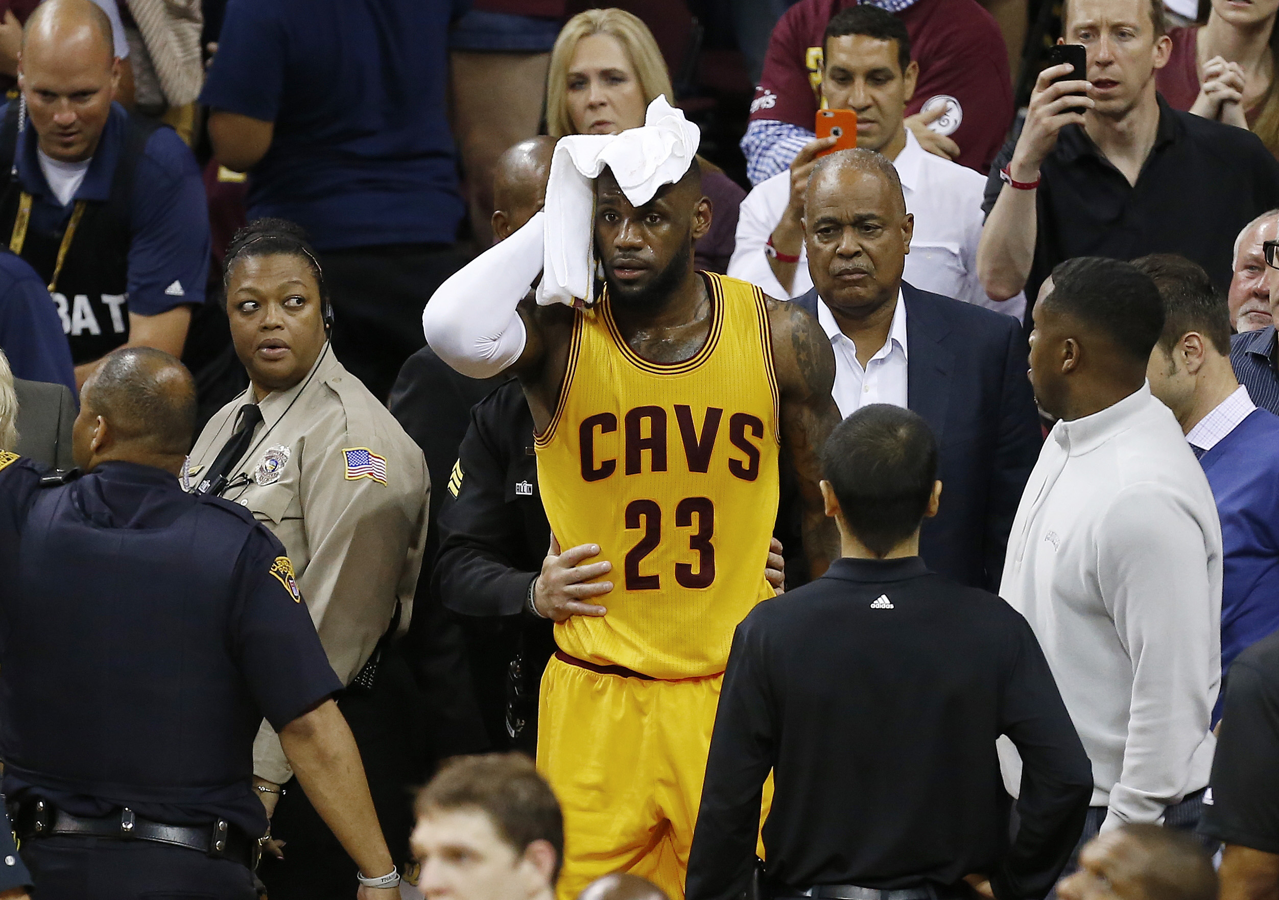 Cleveland Cavaliers forward LeBron James (23) holds a towel to his head after being knocked into the fans during the first half of Game 4 of basketball's NBA Finals against the Golden State Warriors in Cleveland, Thursday, June 11, 2015.