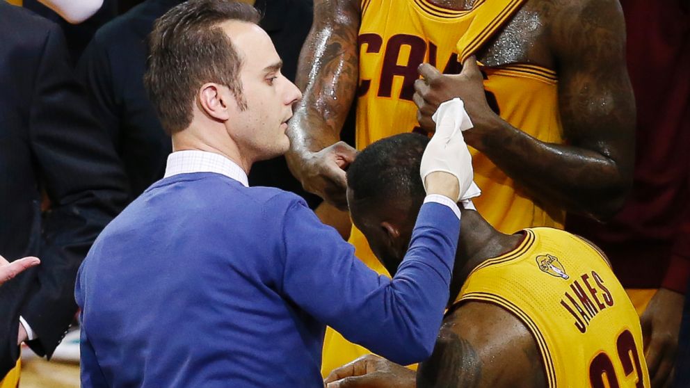 Cleveland Cavaliers forward LeBron James (23) is treated on the bench after being knocked to the ground during the first half of Game 4 of basketball's NBA Finals against the Golden State Warriors in Cleveland, Thursday, June 11, 2015.