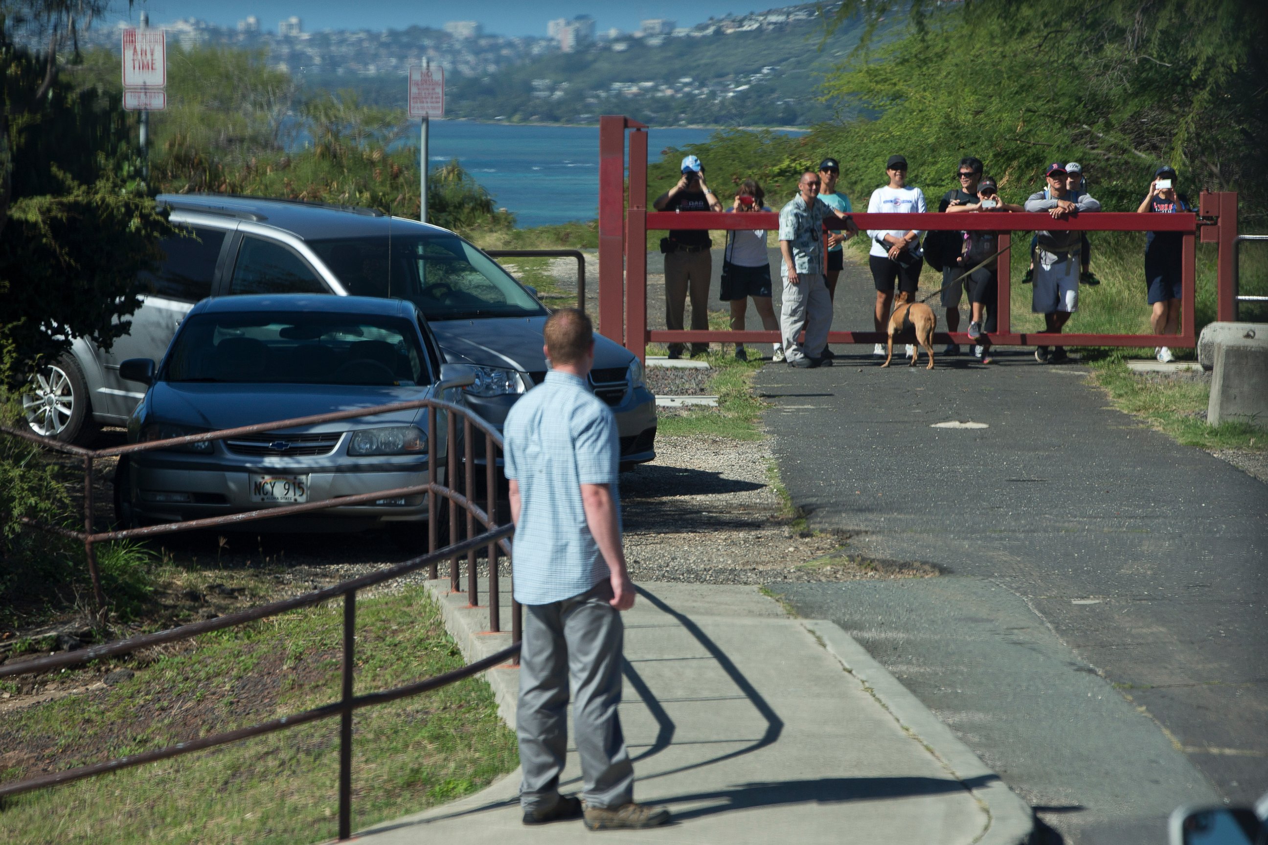 PHOTO: People vie to see past a secret service agent for a glimpse of the motorcade taking President Barack Obama and the first family to Hanauma Bay Nature Preserve, Jan. 1, 2015, on the island of Oahu in Hawaii.