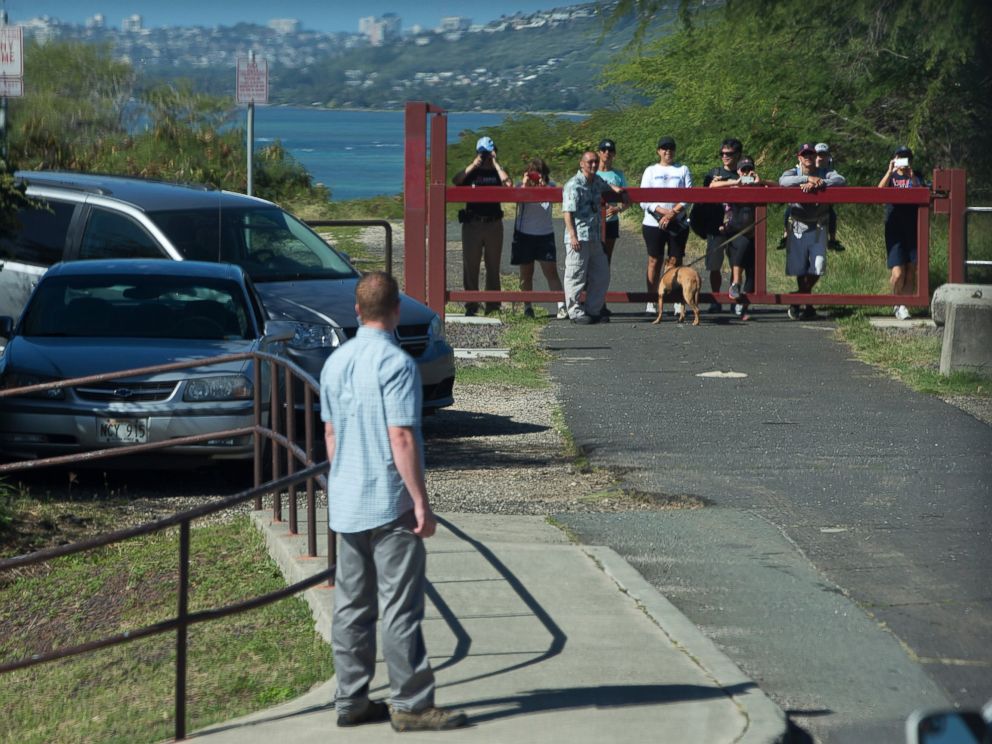 PHOTO: People vie to see past a secret service agent for a glimpse of the motorcade taking President Barack Obama and the first family to Hanauma Bay Nature Preserve, Jan. 1, 2015, on the island of Oahu in Hawaii.