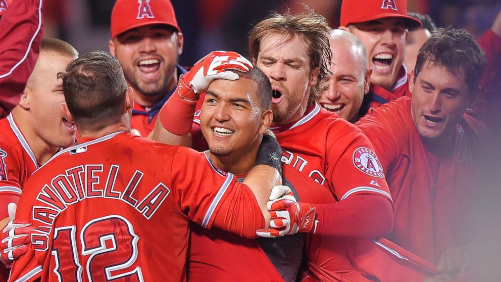 Los Angeles Angels' Carlos Perez, center, is surrounded by teammates after hitting a walk-off home run to beat the Seattle Mariners, May 5, 2015, in Anaheim, Calif.
