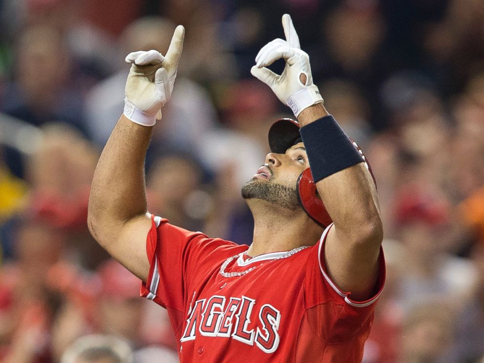 PHOTO: Albert Pujols points upward as he crosses home plate after hitting his 500th career home run, April 22, 2014.