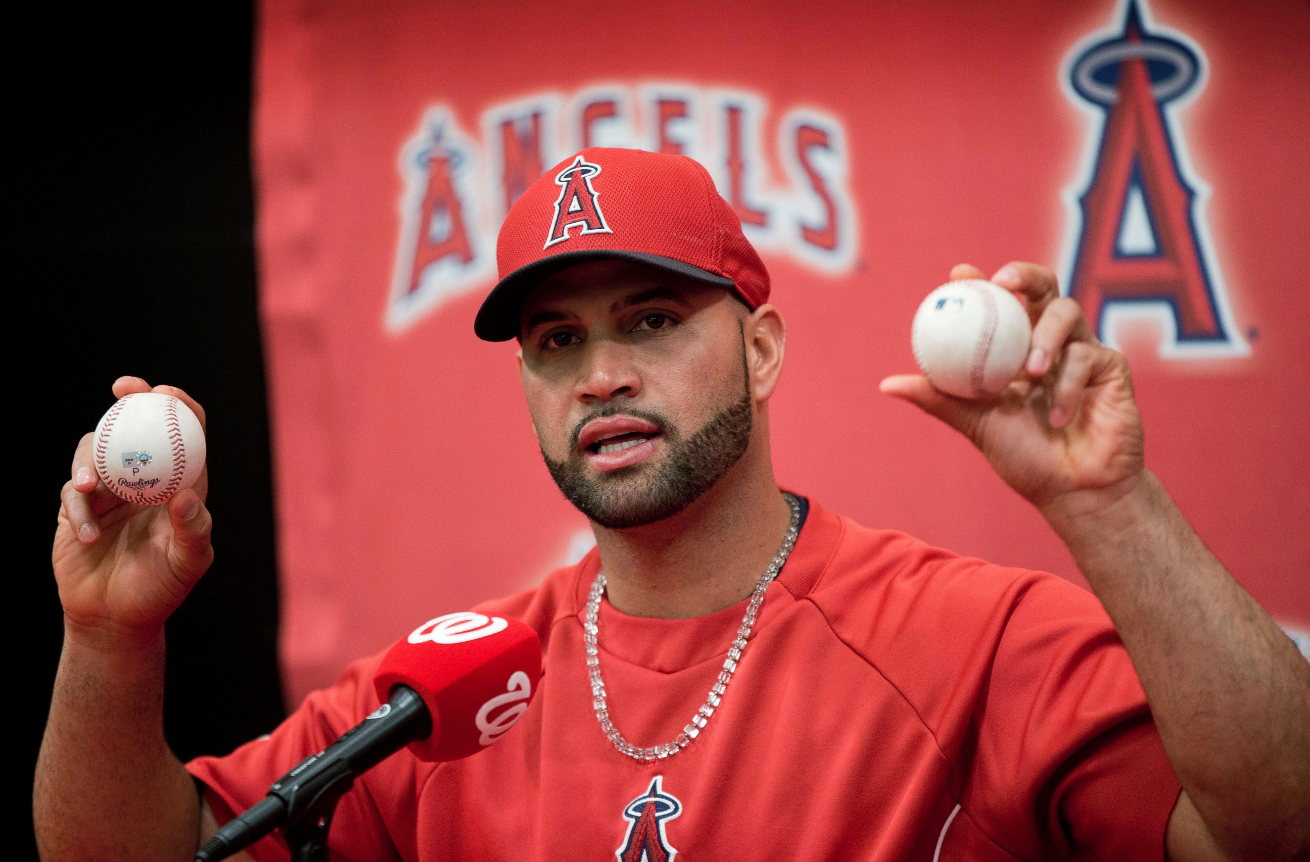 PHOTO: Los Angeles Angels Albert Pujols holds up the balls that he hit for his 499th, right, and 500th, left, career homers, April 22, 2014.