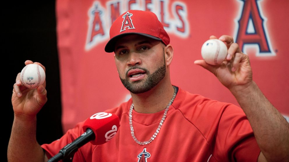 PHOTO: Los Angeles Angels Albert Pujols holds up the balls that he hit for his 499th, right, and 500th, left, career homers, April 22, 2014.